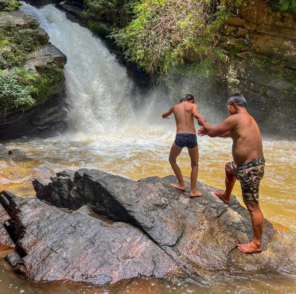 Bambino si tuffa da una cascata nel Mae Wang nel nord della Thailandia